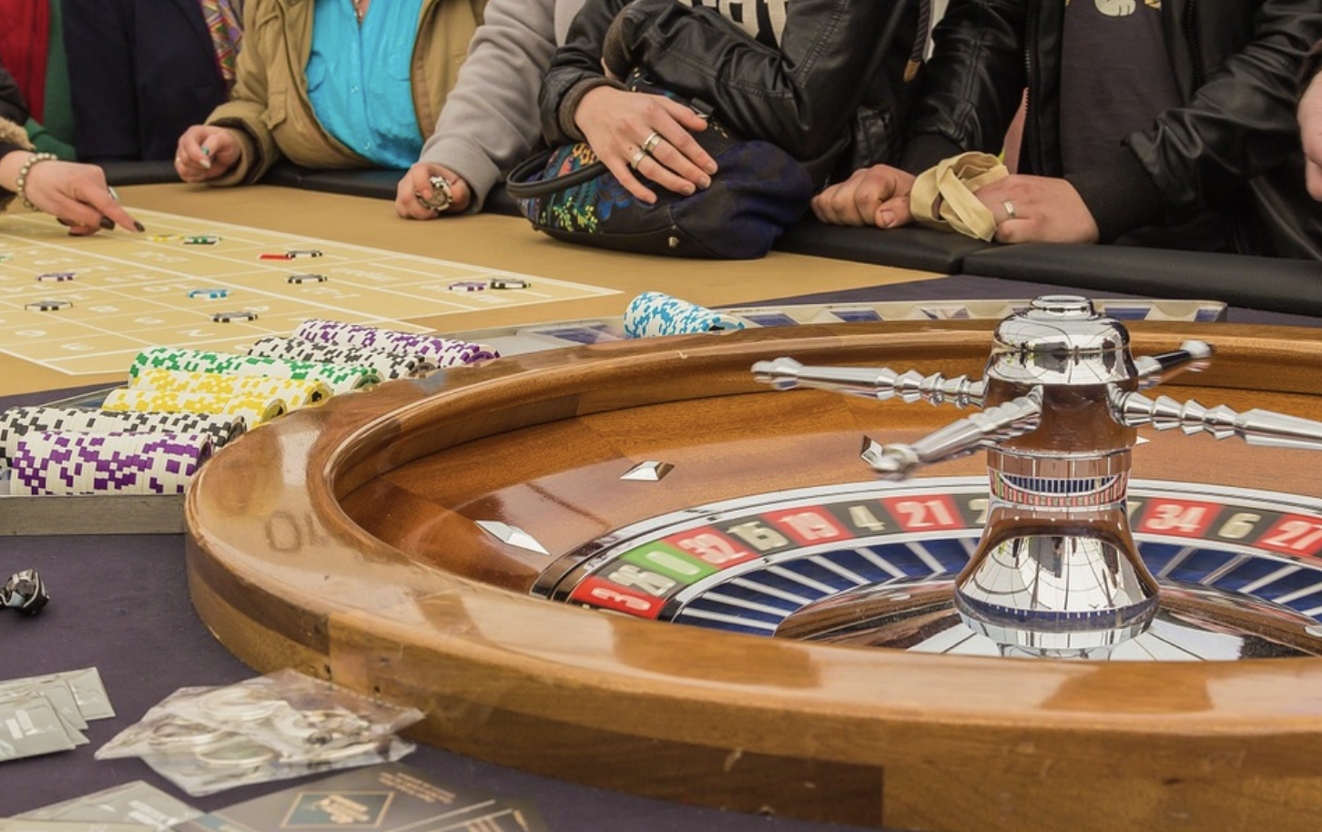 Screenshot 2025-10-27 at 9.20.51 AM A group of people playing a game of roulette.